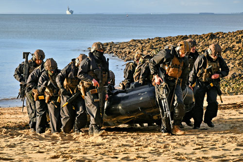Les fusiliers marins hissent leurs embarcations vers le haut de la plage afin de dégager la zone de mise à terre et sécuriser le rivage avant l’arrivée des chalands