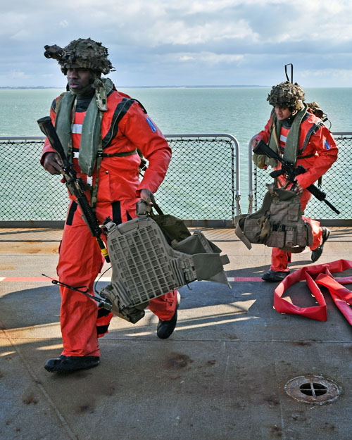 Les PAX (passagers) se dirigent vers l'appareil qui leur est attribué. Ils sont ici revêtus d'une tenue rouge pour faciliter les recherches en cas de crash au-dessus de la mer