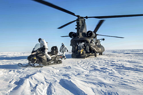 Forces spéciales américaines et norvégiennes avec leurs scooters des neiges après leur débarquement d'un MH-47G Chinook lors de l'exercice Arctic Edge 24