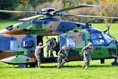 Les militaires débarquent rapidement de l'hélicoptère et se dirigent vers le centre du village